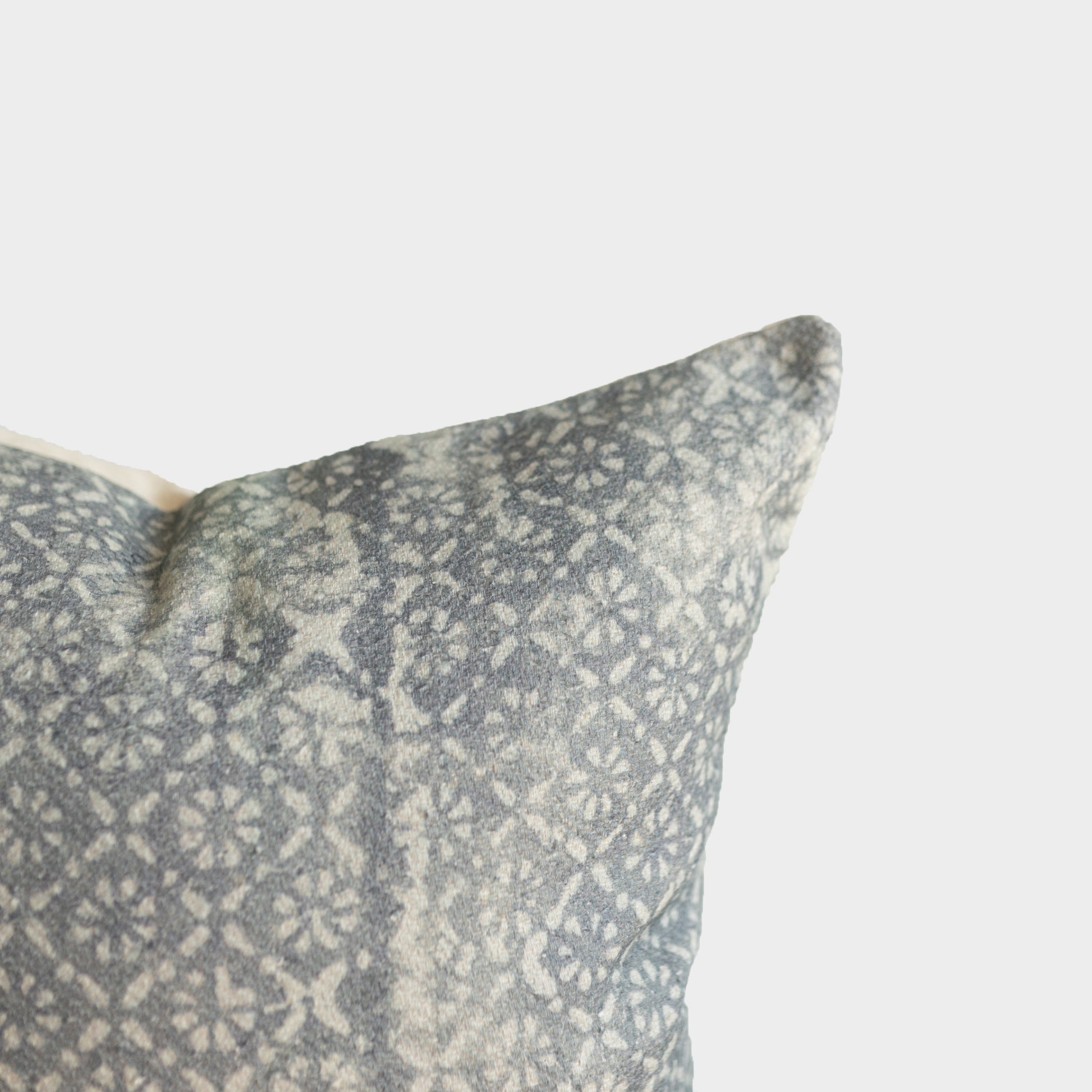Gray and cream woven pillow cover with diamond floral pattern and thick textile weave.
