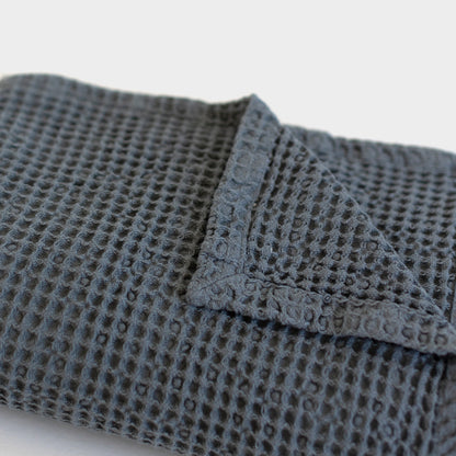 Storm blue waffle blanket with textured grid pattern and folded edge detail.