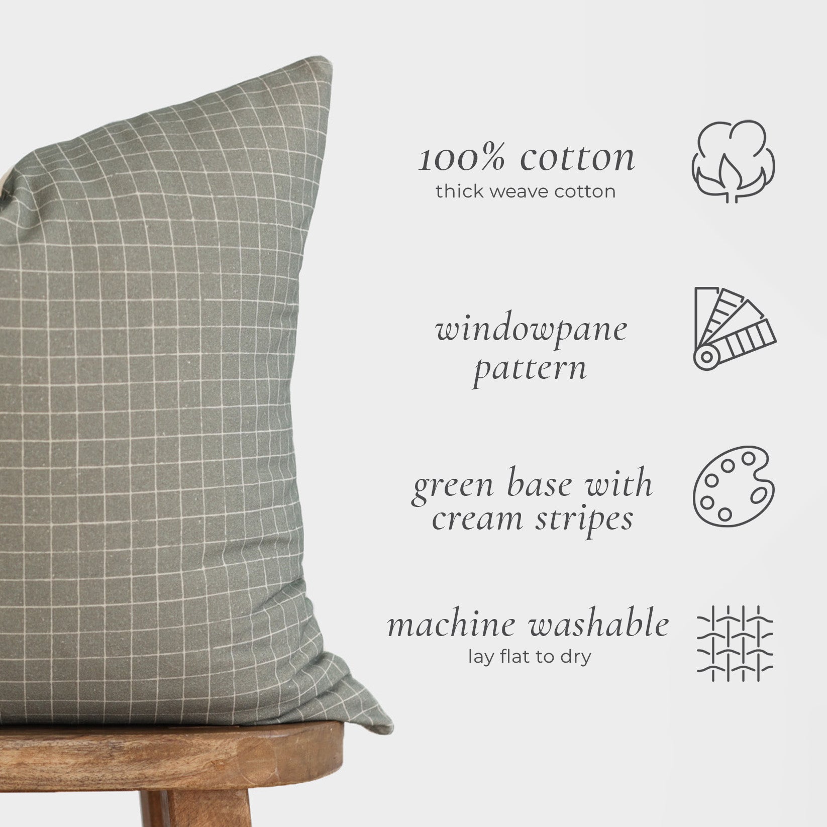 Moss-colored cotton pillow cover with cream windowpane grid pattern displayed on wooden chair.