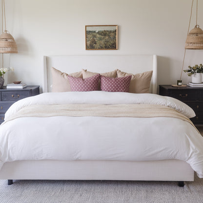 White duvet cover on king-size bed with matching pillowcases and decorative pillows in bedroom setting.