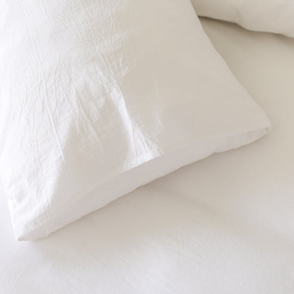 White duvet cover with textured quilted pattern and matching pillowcase on bed.
