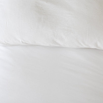 White duvet cover with pillowcase showing textured woven fabric and folded edges.