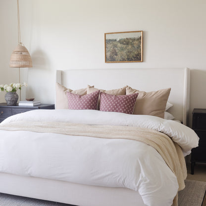 White duvet cover set on king bed with coordinating pillows and throw blanket.