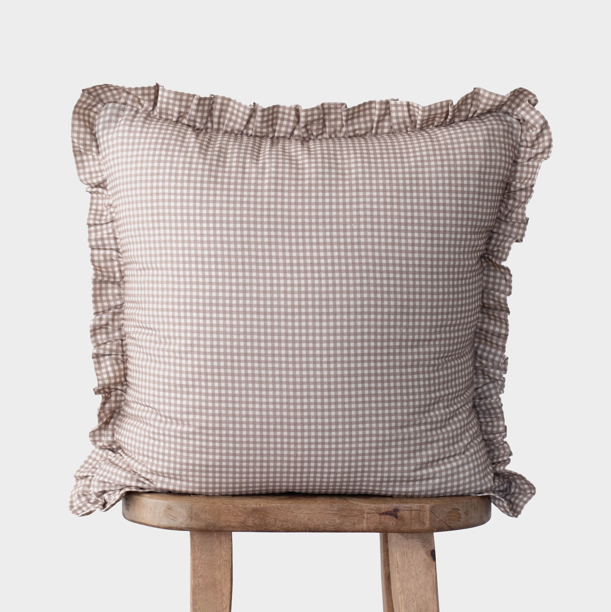 Tan and white mini gingham pillow cover with ruffled edges on all sides.