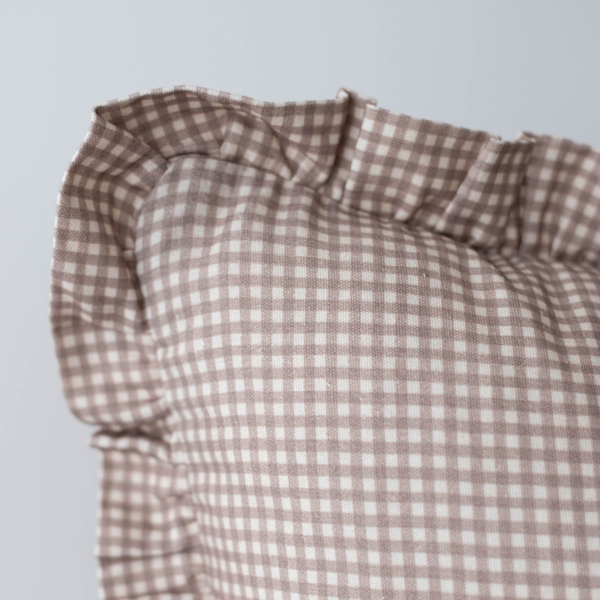 Tan and white mini gingham fabric with ruffled edge detail.