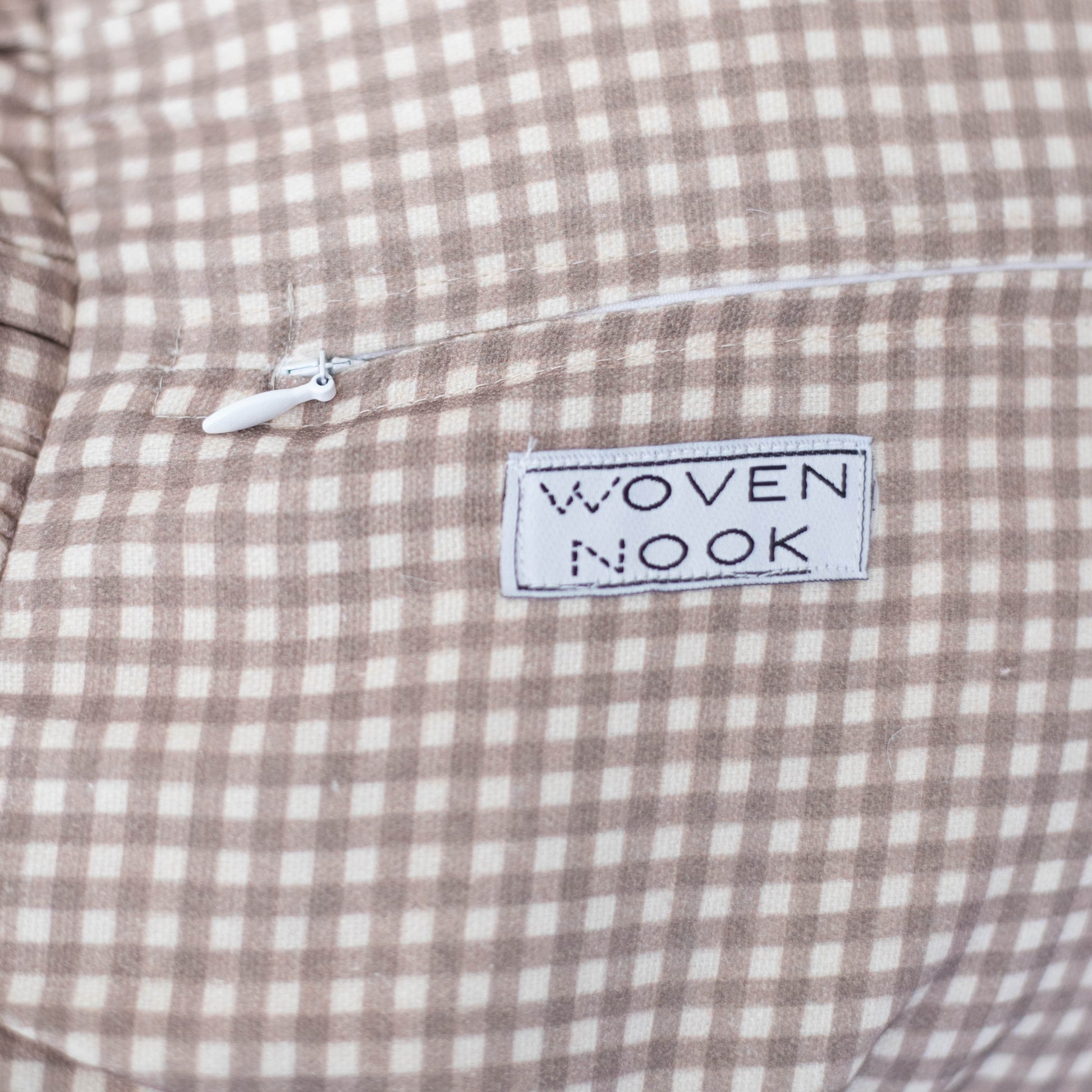 Tan and white mini gingham check fabric with "Woven Nook" brand label and drawstring detail.