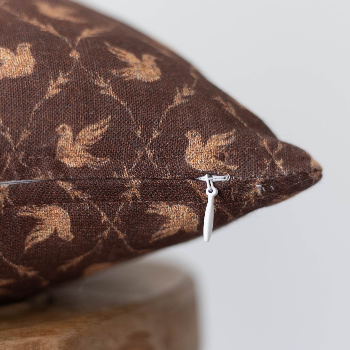 Brown cushion cover with tan leaf pattern and white zip closure, 12x20 inches.