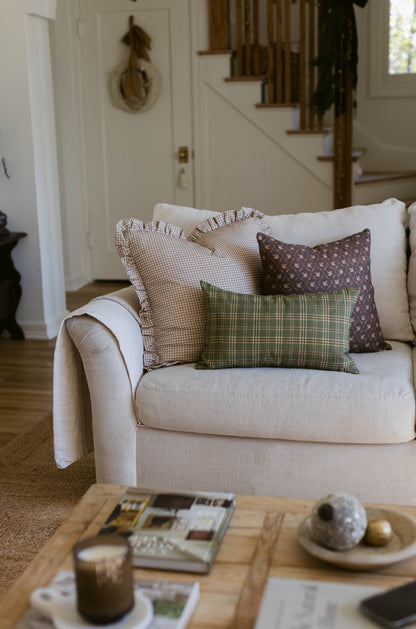 Rectangular pillow with green and cream plaid pattern in 18" x 22" size on cream upholstered chair.