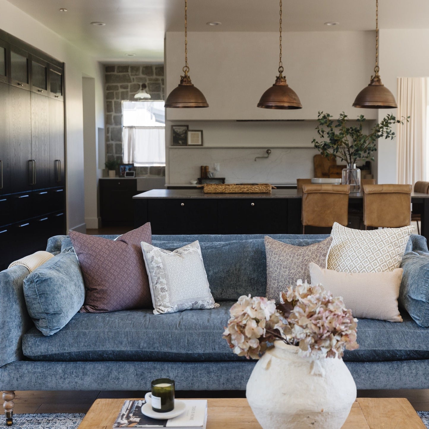 Maroon dome pendant light with chain suspension and brass fixture, shown hanging above kitchen island.