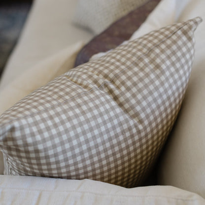 Tan and white gingham patterned pillow with small checked squares.