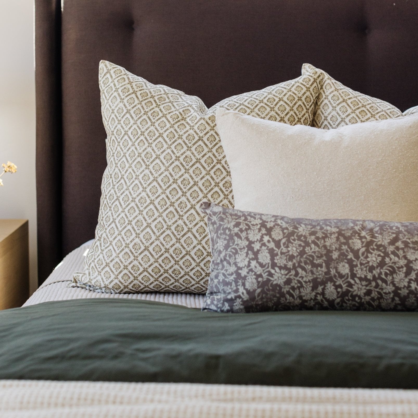 Gretta lumbar pillow with tan and cream geometric diamond pattern displayed on bed with coordinating pillows and bedding.