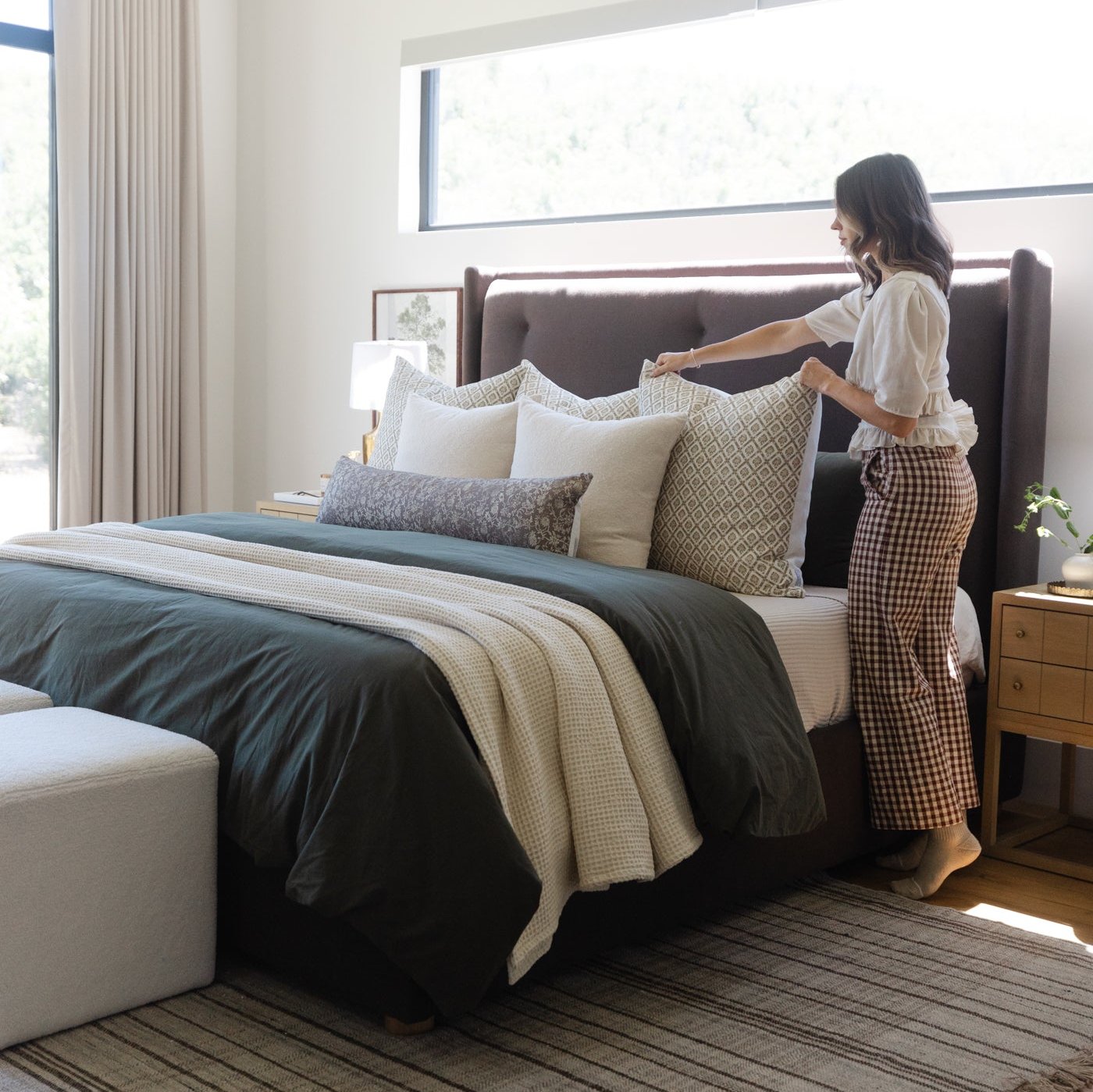 Beige lumbar pillow with geometric diamond pattern displayed on a bed with coordinating bedding.