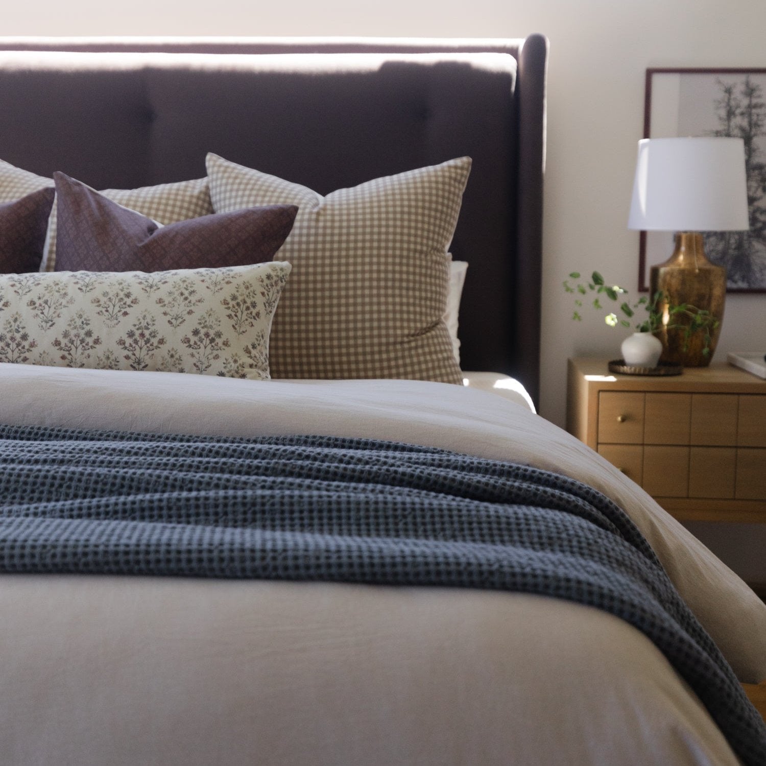 Afton lumbar pillow in tan gingham pattern displayed on bed with coordinating plaid and floral pillows.