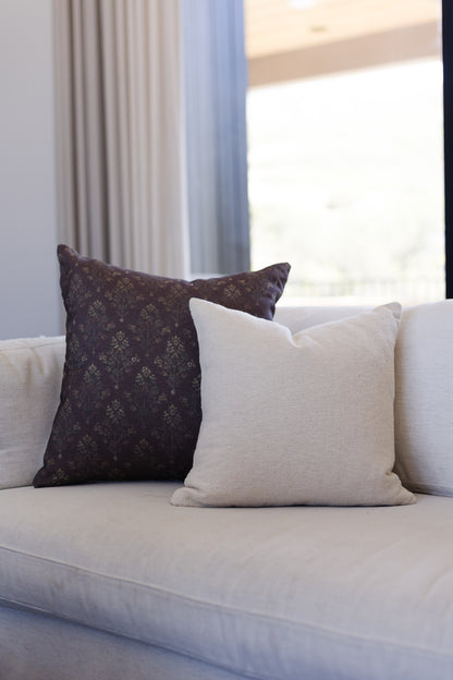 Off-white boucle rectangular pillow with textured weave displayed on a light gray sofa.