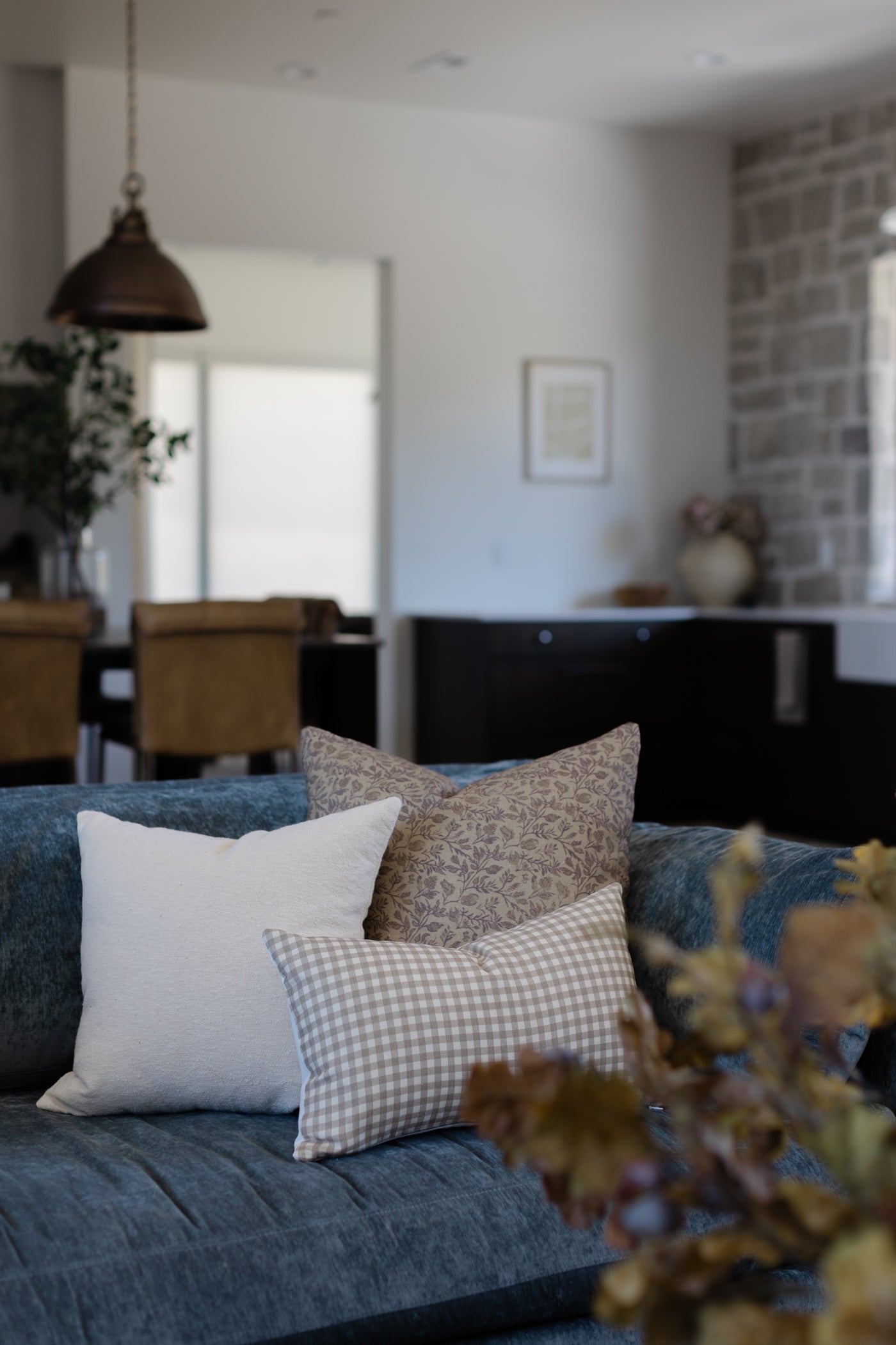 Off-white boucle pillow with textured weave displayed on a blue sofa.