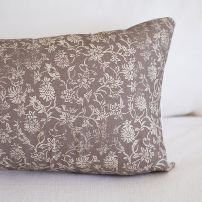 Rectangular lumbar pillow with taupe fabric featuring cream floral and leaf pattern throughout.