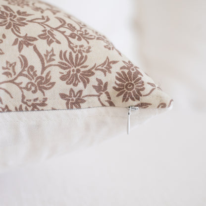 Rectangular pillow with taupe floral pattern on cream background and white zipper closure visible on side.