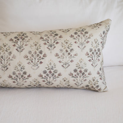 Rectangular lumbar pillow with cream linen fabric printed with small burgundy and brown botanical flowers in repeating patter