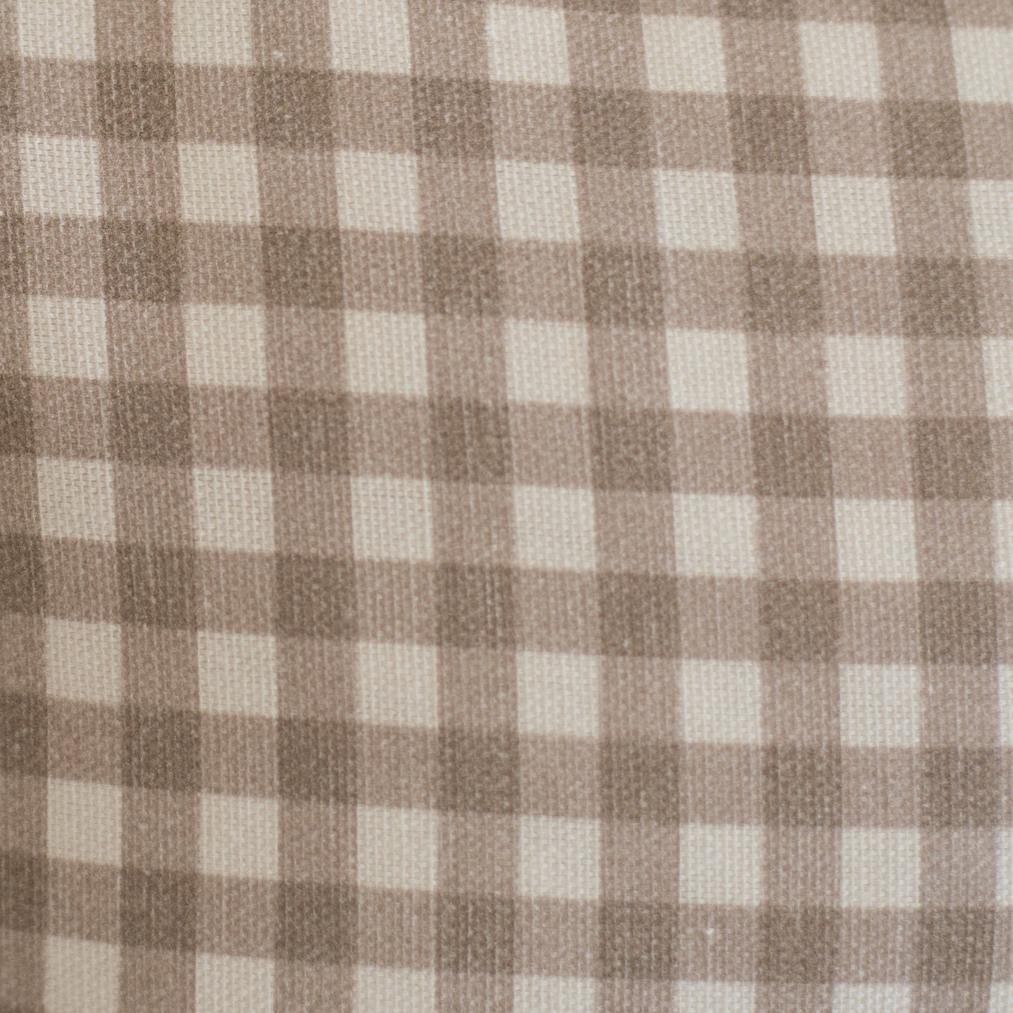 Tan and cream gingham check pattern on woven lumbar pillow fabric.