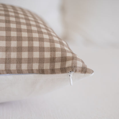 Tan and cream gingham check lumbar pillow with white zipper closure.