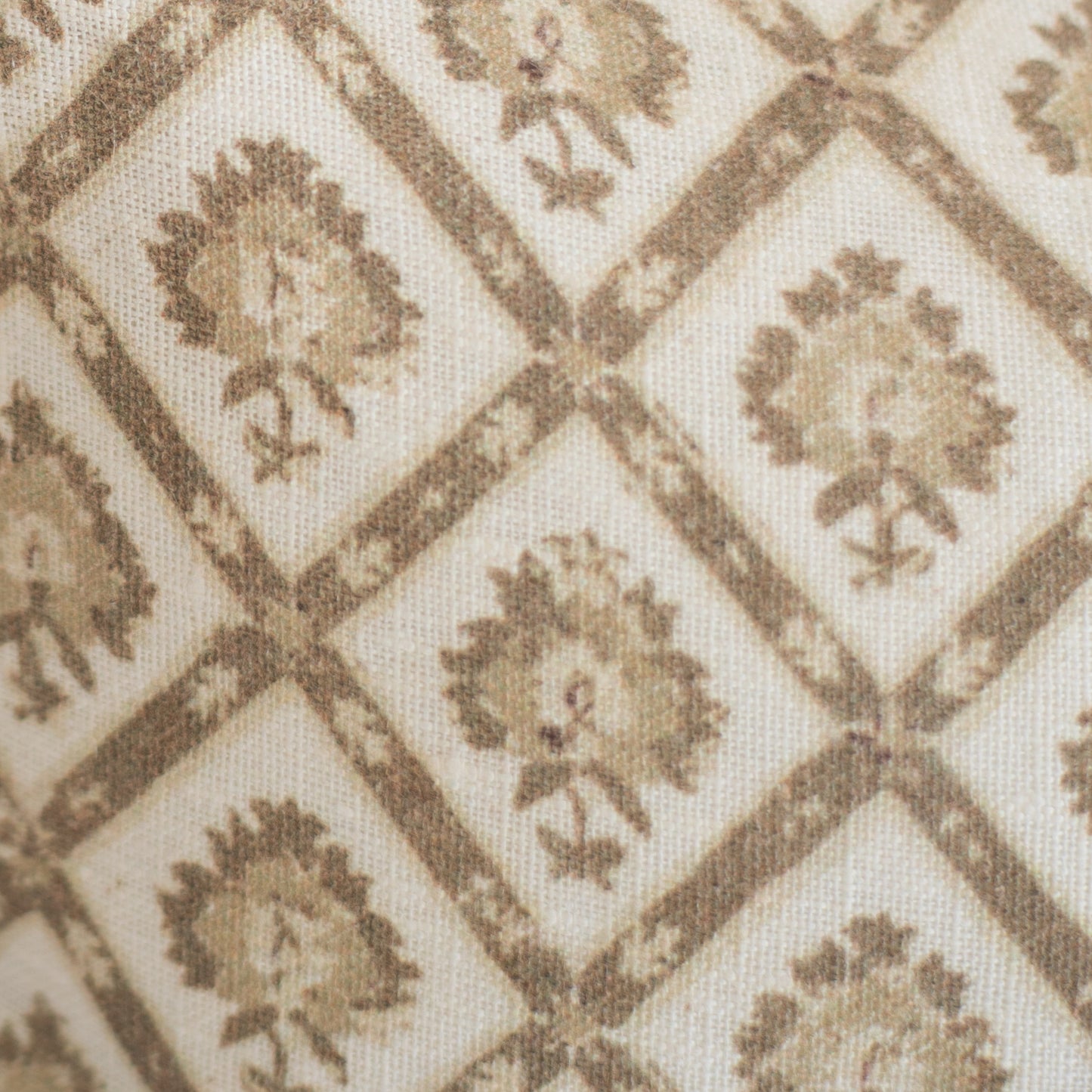 Beige linen lumbar pillow with tan geometric diamond pattern containing repeated floral motifs.