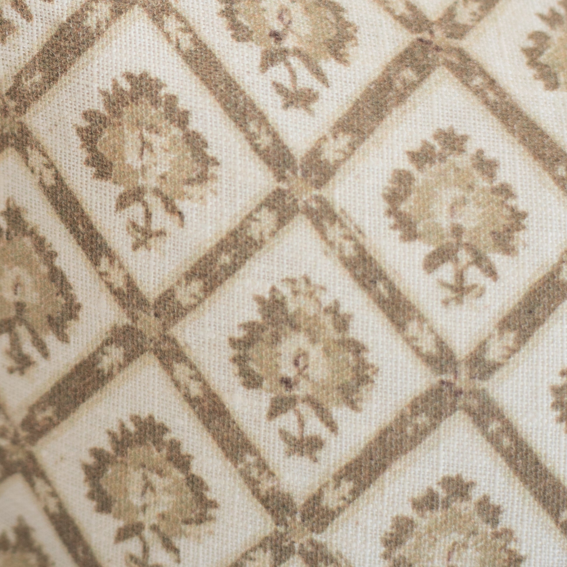 Beige linen lumbar pillow with tan geometric diamond pattern containing repeated floral motifs.