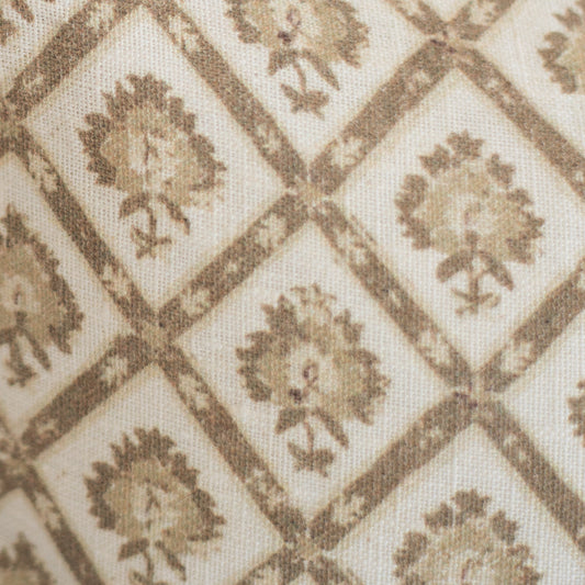 Beige linen lumbar pillow with tan geometric diamond pattern containing repeated floral motifs.