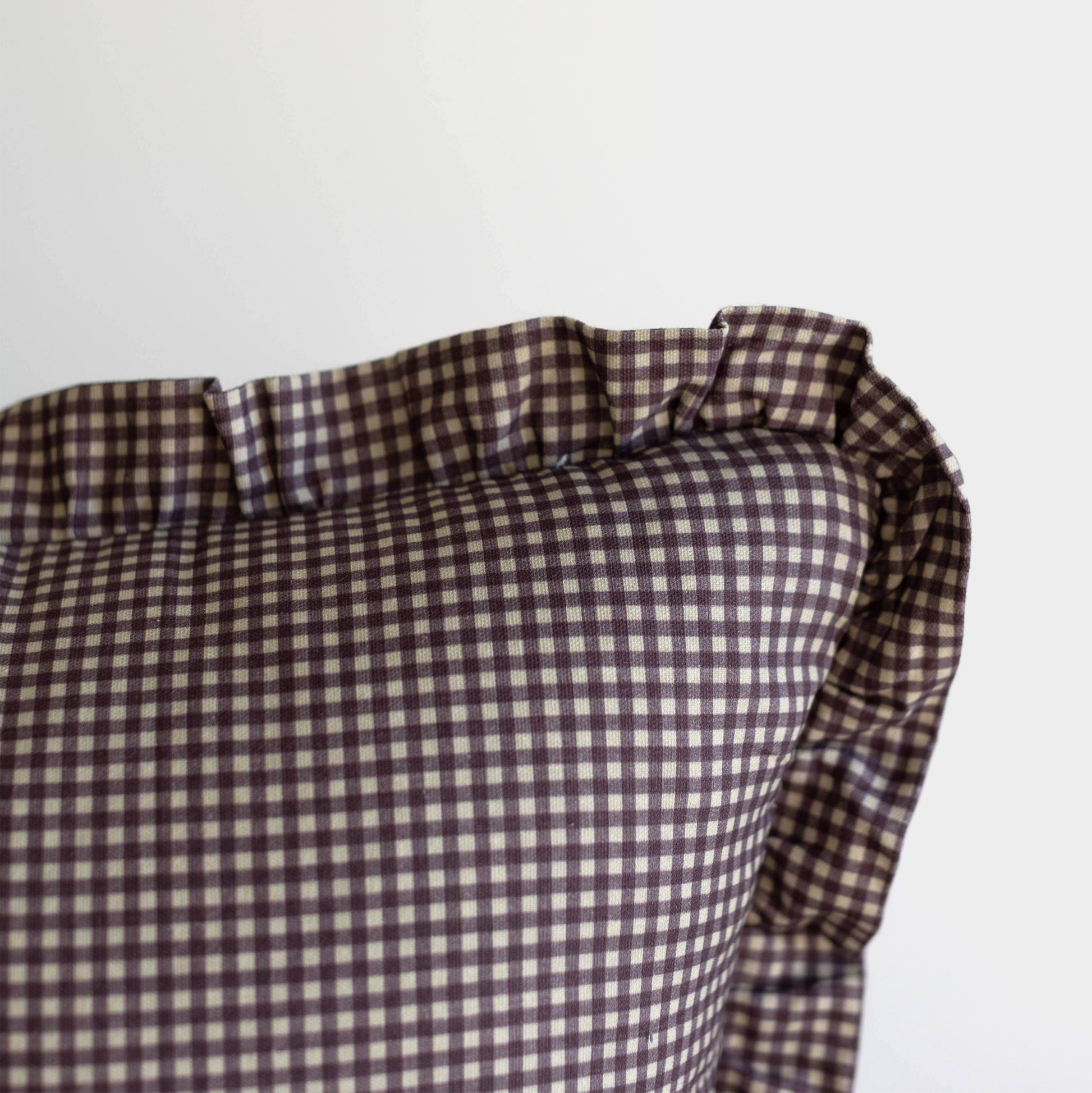 Plum and white mini gingham pillow with ruffled edges.