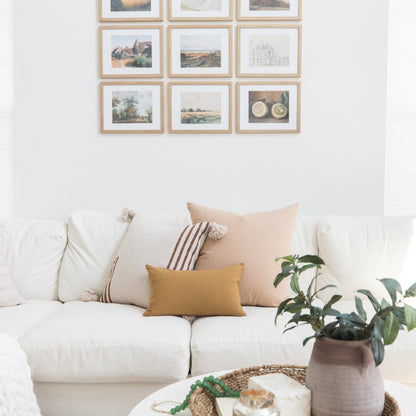 Nine framed landscape and botanical prints with natural wood frames arranged in a 3x3 grid on white wall.
