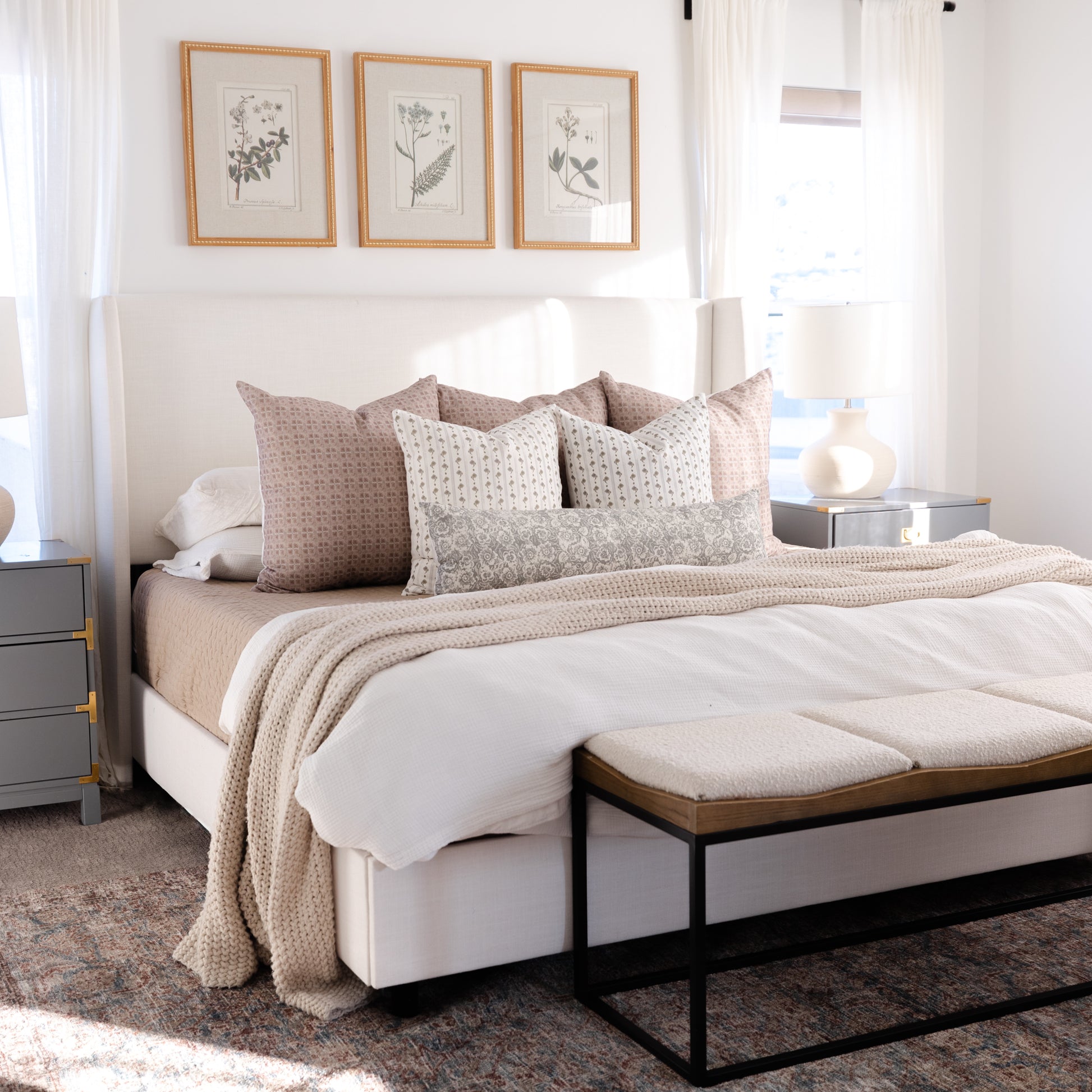 Gray and cream lumbar pillow with small geometric pattern displayed on bed with matching bedding and decor.