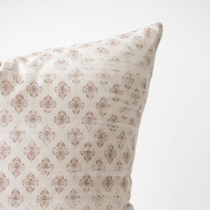 Cream pillow with tan diamond-shaped damask pattern throughout fabric surface.