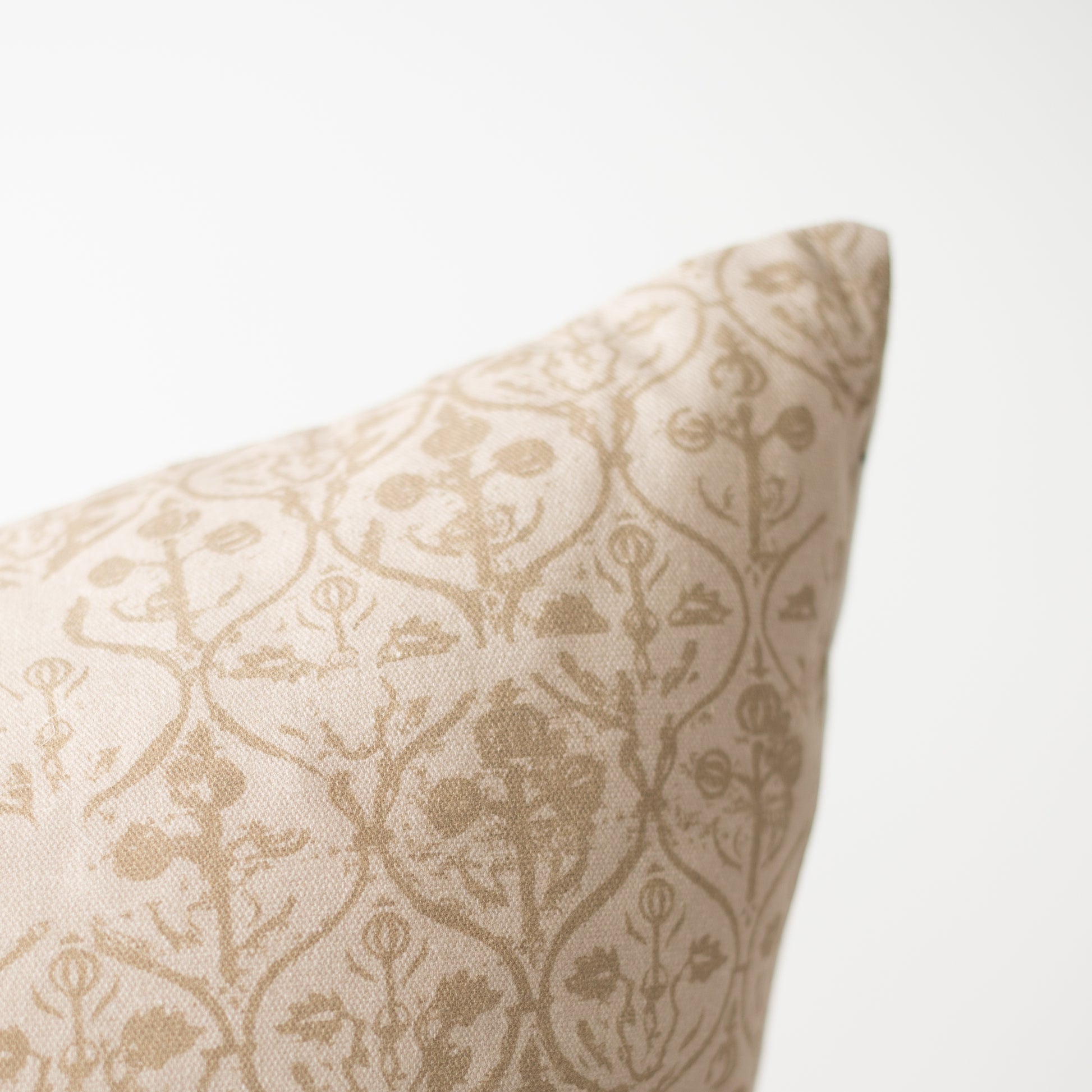 Cream pillow with beige damask pattern and piped edge detail.