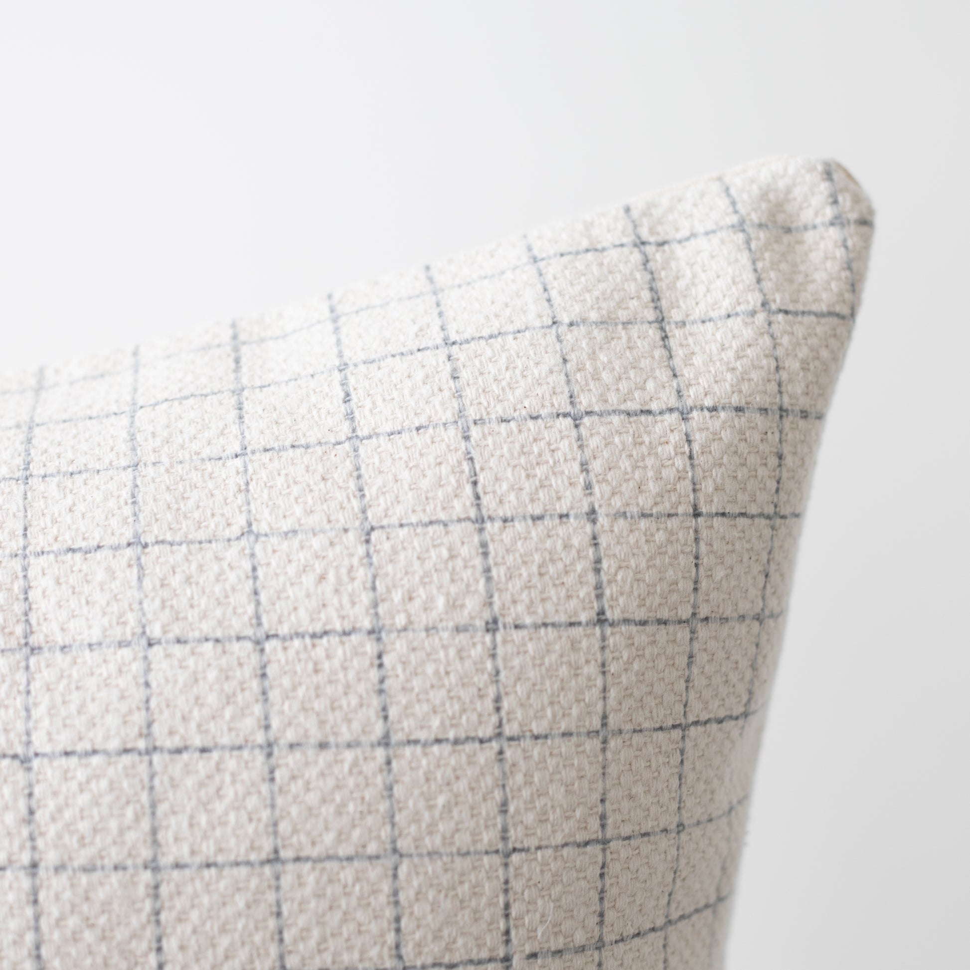 Beige linen pillow with blue grid pattern, 22 inches.