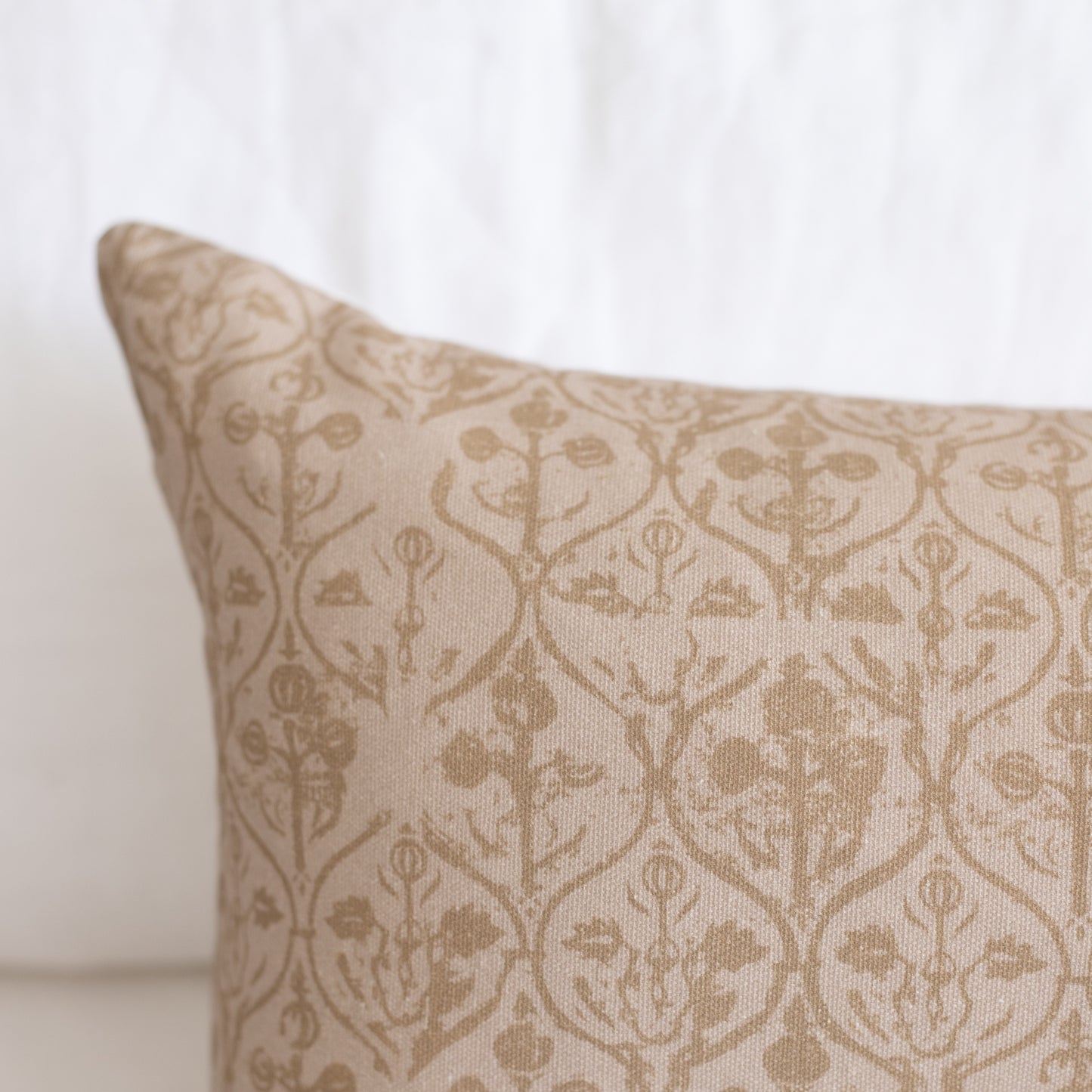 Rectangular pillow with beige and cream floral damask pattern.
