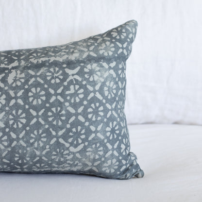 Gray lumbar pillow with cream diamond and floral geometric pattern on white background.