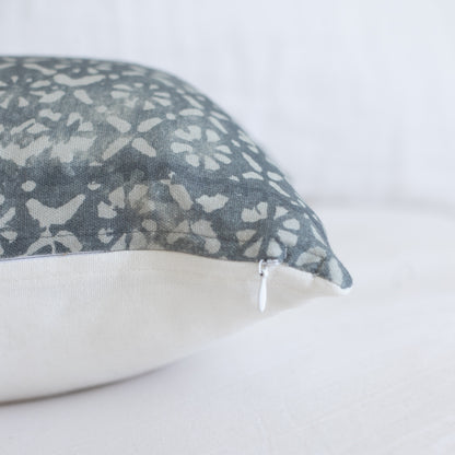 Gray lumbar pillow with cream floral diamond pattern and cream fabric back, zipper closure visible.