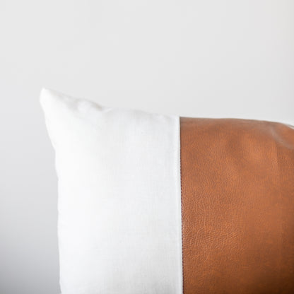 Two rectangular pillows with white textured front and tan leather back, 12x20 inches.