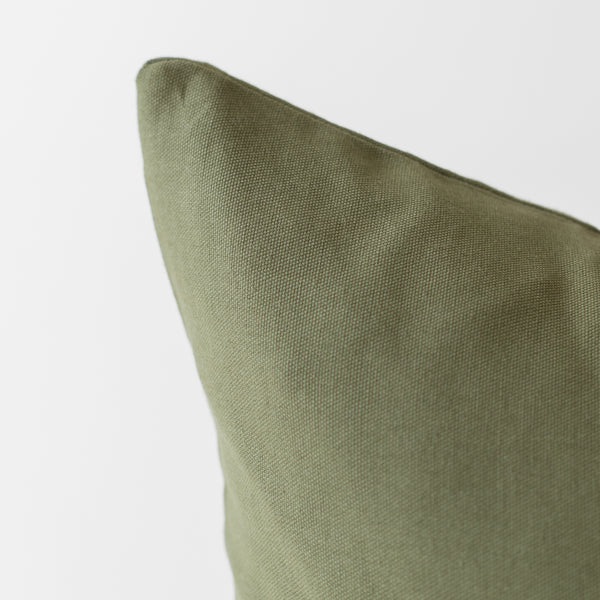 Olive green pillow cover with textured weave fabric in close-up view.