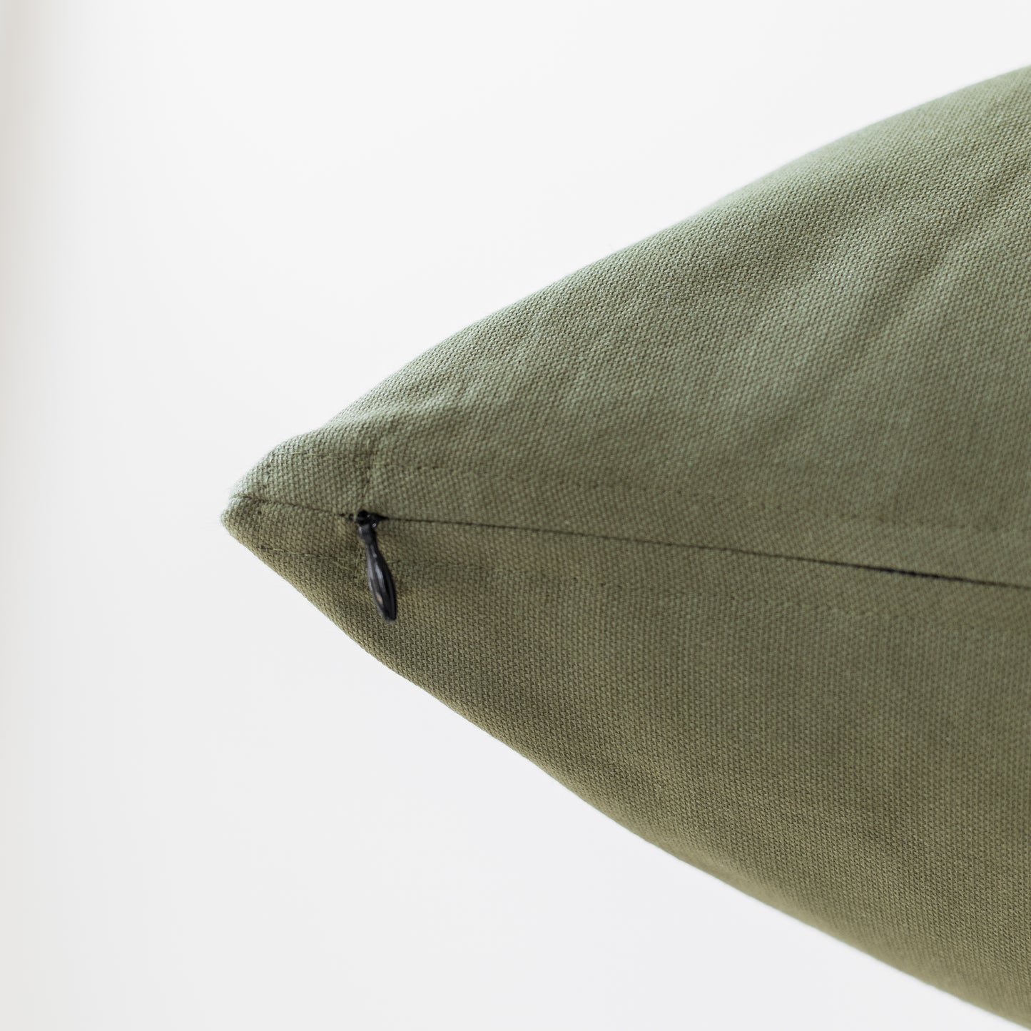 Olive green pillow with textured linen weave fabric and concealed zipper closure.