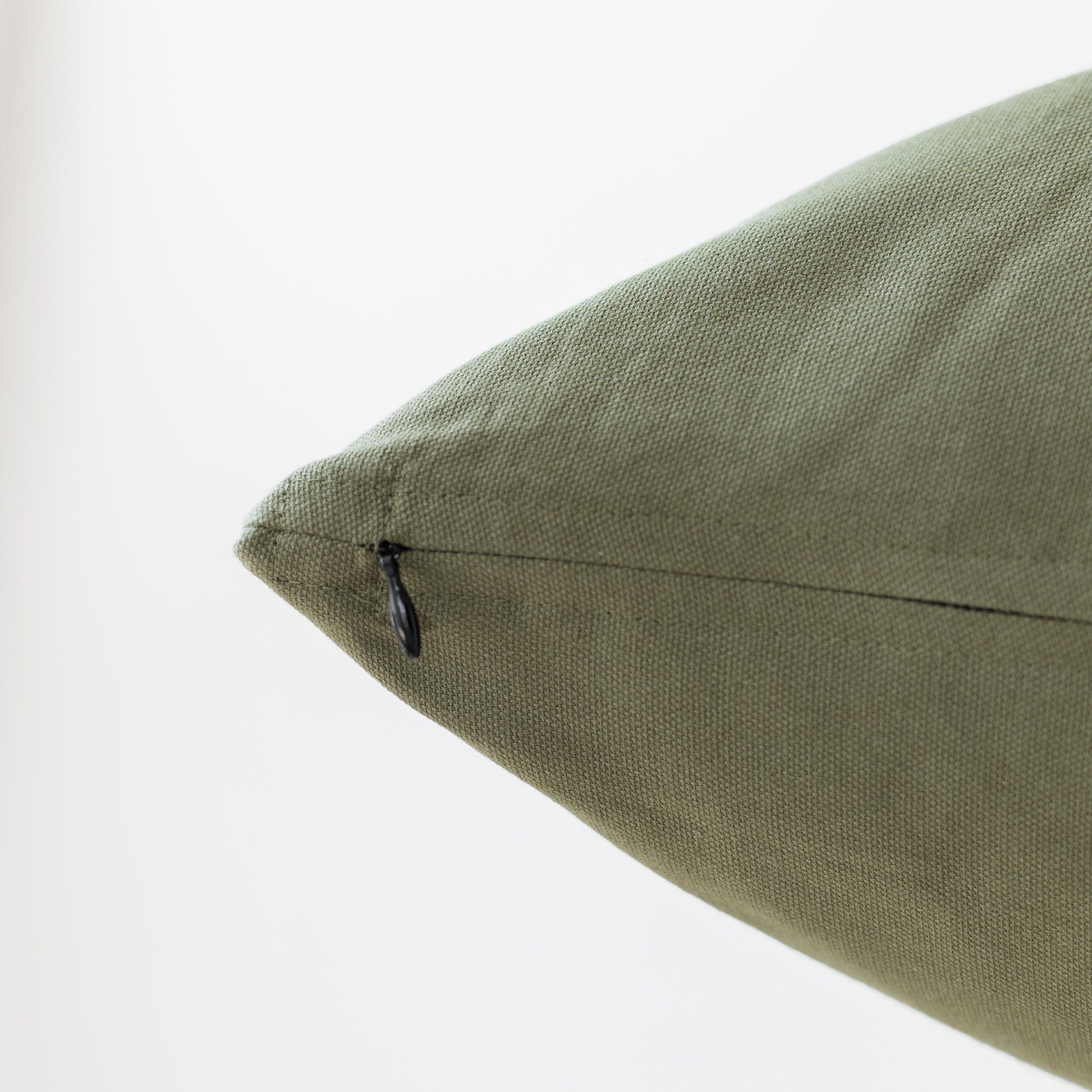 Olive green pillow with textured linen weave fabric and concealed zipper closure.