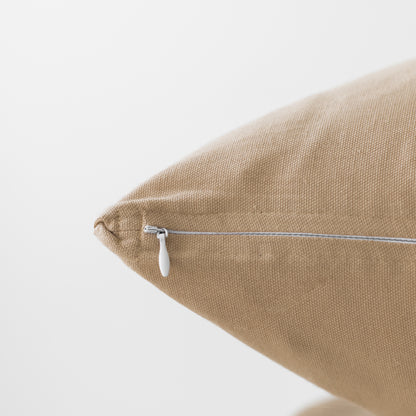 Tan linen pillow with white zipper closure on side seam.