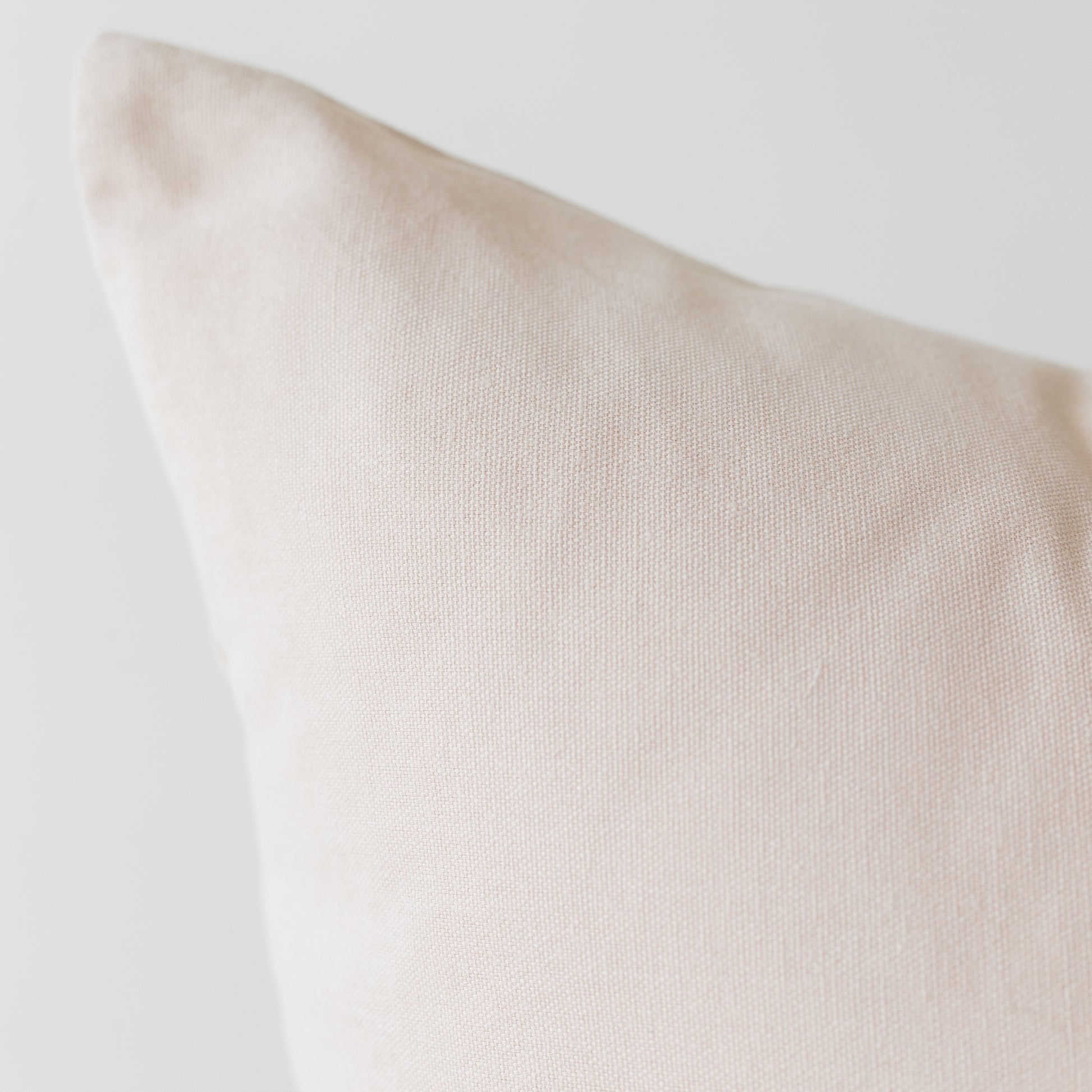 Cream-colored pillow with textured woven fabric and soft edges.