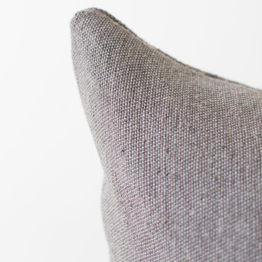 Gray woven textile pillow with textured fabric surface and pointed corner detail.