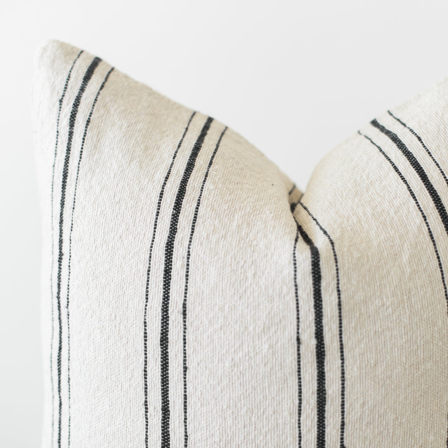 Cream and black striped pillow cover with vertical woven lines detail.