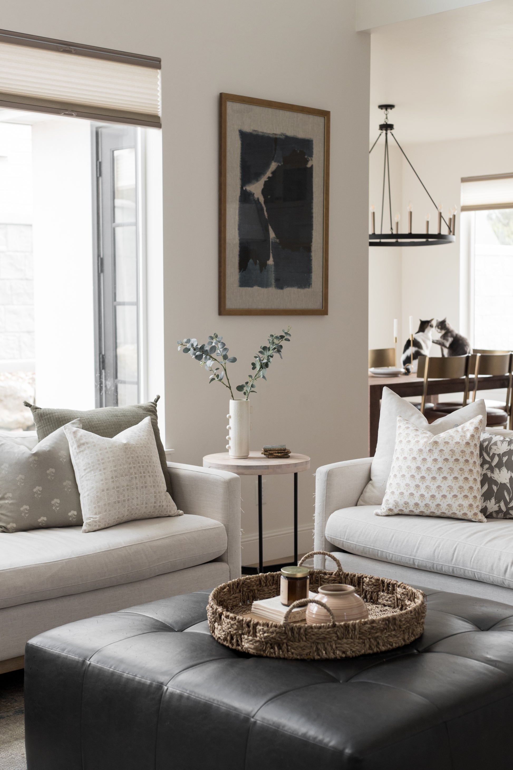 Four cream-colored decorative pillows with small floral pattern displayed on beige upholstered seating in a living room setti