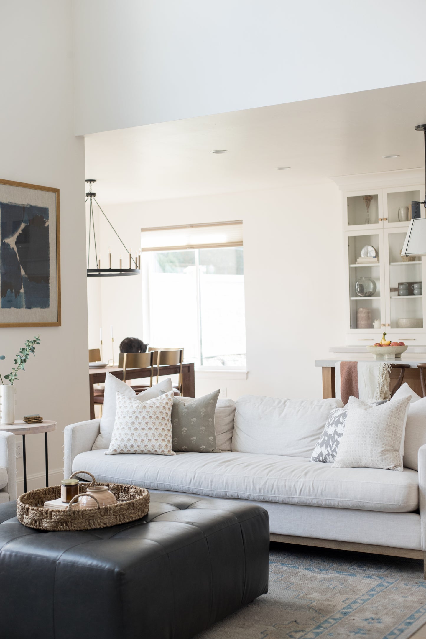 Four cream and gray patterned throw pillows arranged on a white sofa in a modern living room setting.