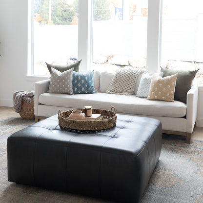 Four 18-inch decorative pillows with varied patterns in gray, blue, cream, and tan displayed on a white sofa.