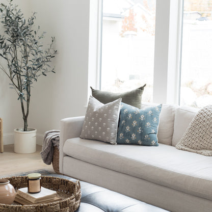 Four 18-inch decorative pillows with floral and geometric patterns in gray, blue, and cream displayed on a light gray sofa.