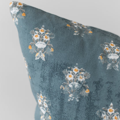 Teal pillow with white and orange floral pattern, 18 inches.
