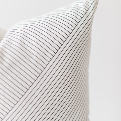 White pillow with thin dark gray pinstripes and ribbed texture.